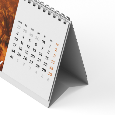 Minimalist desk calendar in tent format, showing the monthly grid with spiral binding and clean white design.