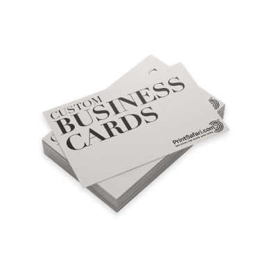 Stack of custom business cards with a clean beige design, featuring bold black serif typography and PrintSafari.com branding, displayed on a white background.