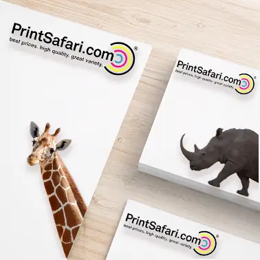 Two custom-shaped stickers featuring a giraffe and a rhinoceros next to rectangular stickers with the PrintSafari.com logo, placed on a light wooden surface.