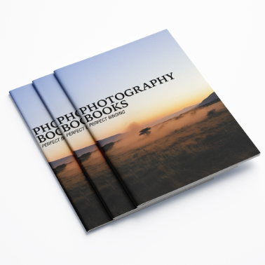 Stack of landscape photography booklets with a sunset cover showing an elephant silhouette, neatly arranged on a white background.